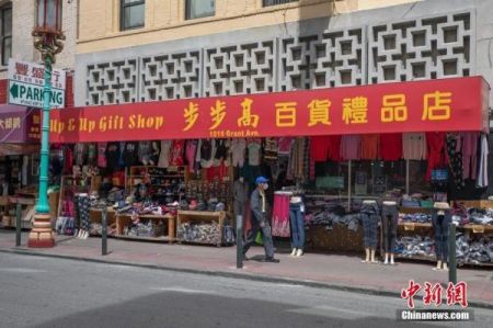 　　当地时间5月18日，一名戴口罩男子路过美国旧金山华埠一家店铺。中新社记者 刘关关 摄