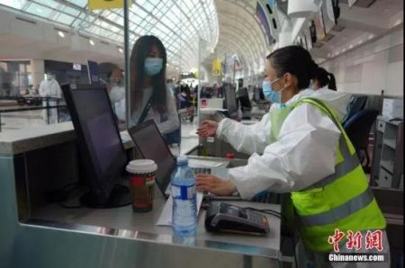 　资料图：中国东方航空公司工作人员在多伦多皮尔逊国际机场为准备直飞上海的乘客办理值机手续。中新社记者 余瑞冬 摄