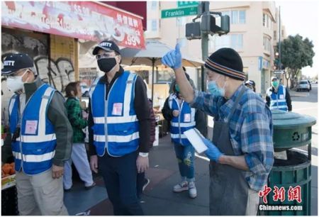 资料图：美国加州奥克兰唐人街的商户和居民自发组成多个义工安全巡逻队，维护当地安全。图为一位商贩向巡逻队竖起大拇指。中新社记者 刘关关 摄