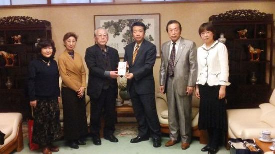 陈铮参赞（右三）接受日本文化振兴会寄付的善款。