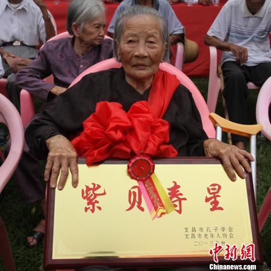 百岁老人获颁“紫贝寿星”牌匾。　薛文埔　摄