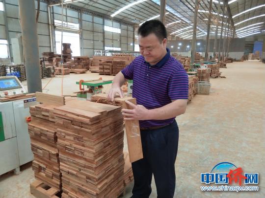 图为张廷江在他的红木工厂中工作。　中老友谊学校供图