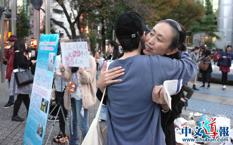 11月12日，江歌母亲江秋莲在池袋呼吁联署，与声援的留学生拥抱。本报记者