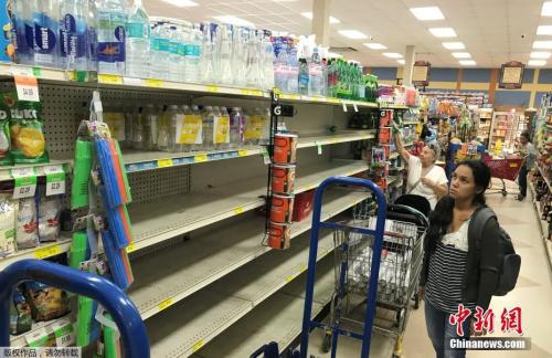 资料图：图为美国迈阿密民众在超市采购物资。